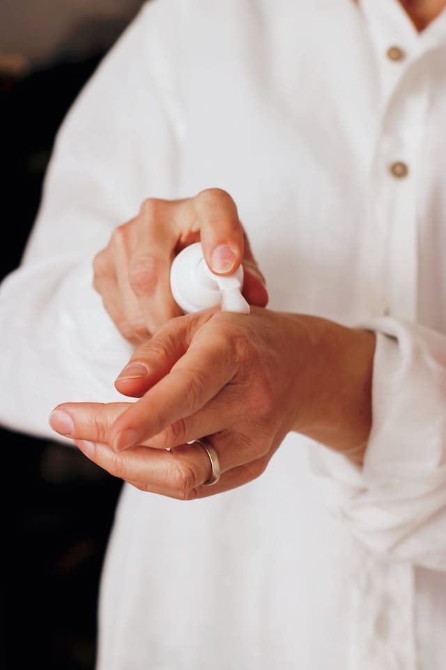 Femme appliquant de la crème avec glycérine sur ses mains